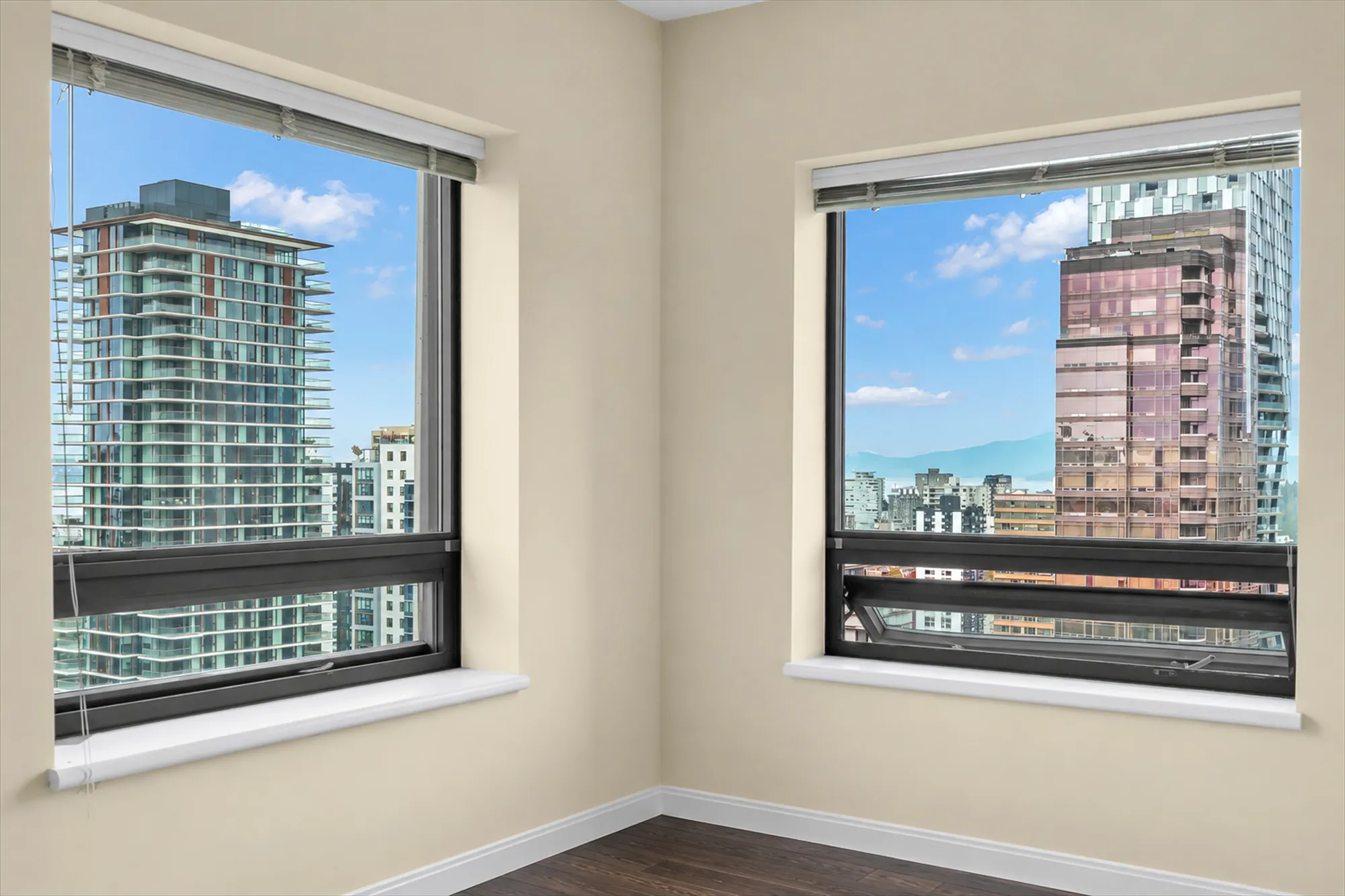 The two windows of the small bedroom, empty, with the towers, the water and the mountains beyond