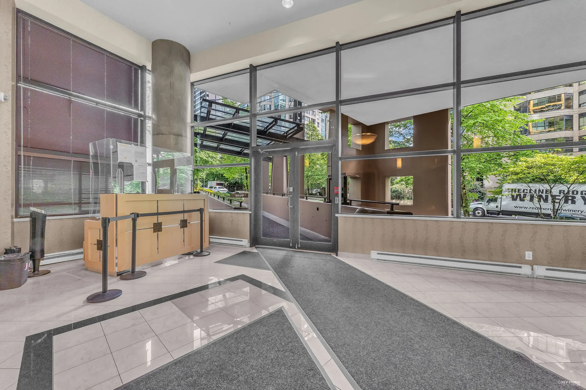 The concierge desk in the lobby, glass doors to the street, a stone floor
